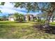 Beautiful home exterior featuring a lush green lawn, mature trees, and a charming front entrance at 12650 Montigello Ct, Englewood, FL 34223
