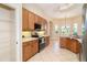 Well-equipped kitchen with modern appliances, wooden cabinetry, pantry, and views of the large living area at 12650 Montigello Ct, Englewood, FL 34223