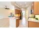Open kitchen featuring wood cabinets, an island, tile flooring, and stainless appliances at 12650 Montigello Ct, Englewood, FL 34223