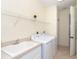 Bright laundry room with washer, dryer, sink, and wire shelving for easy and organized storage at 12650 Montigello Ct, Englewood, FL 34223