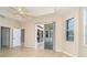 Spacious living room with tile floors, ceiling fan, and doors leading to patio at 12650 Montigello Ct, Englewood, FL 34223