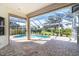 Covered outdoor patio with brick flooring overlooking screened-in pool and green backyard at 12650 Montigello Ct, Englewood, FL 34223