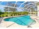 Sparkling pool with covered enclosure and beautiful landscaping in backyard at 12650 Montigello Ct, Englewood, FL 34223