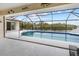 Screened-in pool and patio area with waterfront view and surrounding trees create a serene retreat at 2295 Chilcote Ter, Port Charlotte, FL 33981