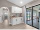 Wet bar with sink and white cabinetry, adjacent to sunroom and pool at 254 Mark Twain Ln, Rotonda West, FL 33947