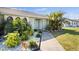 Charming single-story home featuring a beautifully landscaped front yard with lush tropical foliage and a walkway to the front door at 254 Mark Twain Ln, Rotonda West, FL 33947