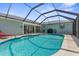 Enclosed pool area with comfortable seating, a grill, and direct access to the home at 254 Mark Twain Ln, Rotonda West, FL 33947