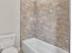 Elegant bathroom featuring a white tub and beautiful marble-patterned tile surround at 2814 Vogler Ln, North Port, FL 34286