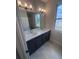 Bathroom featuring a double sink vanity, quartz countertop, and large mirror at 2814 Vogler Ln, North Port, FL 34286