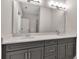 Bathroom vanity with double sinks, gray cabinets, white countertops, and a large mirror at 2814 Vogler Ln, North Port, FL 34286