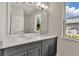 Double vanity bathroom with large mirror, modern lighting fixtures, and natural light at 2814 Vogler Ln, North Port, FL 34286