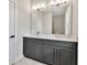 Bathroom featuring a double vanity with gray cabinets, quartz countertops, and modern fixtures at 2814 Vogler Ln, North Port, FL 34286