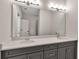 Bathroom vanity with double sinks, gray cabinets, white countertops, and a large mirror at 2814 Vogler Ln, North Port, FL 34286