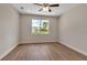 Bedroom with wood-look floors, ceiling fan, and a large window with a view at 2814 Vogler Ln, North Port, FL 34286