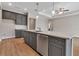 Spacious kitchen with a large island, gray cabinets, stainless steel appliances, and light wood-look flooring at 2814 Vogler Ln, North Port, FL 34286