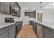 Modern kitchen featuring gray cabinets, stainless steel appliances, white countertops, and wood-look flooring at 2814 Vogler Ln, North Port, FL 34286