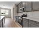 Updated kitchen featuring stainless steel appliances, gray cabinets, white countertops, and light wood-look flooring at 2814 Vogler Ln, North Port, FL 34286