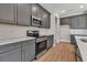 Modern kitchen features gray cabinets, stainless steel appliances, white subway tile backsplash, and light wood-look flooring at 2814 Vogler Ln, North Port, FL 34286