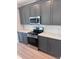 Modern kitchen with gray cabinets, stainless steel appliances, and white countertops at 2814 Vogler Ln, North Port, FL 34286