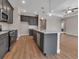 An open kitchen featuring gray cabinets, stainless steel appliances, a large island, and wood-look flooring at 2814 Vogler Ln, North Port, FL 34286
