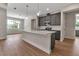 Well-lit kitchen showcasing gray cabinets, stainless steel appliances, an island with pendant lights, and wood-look flooring at 2814 Vogler Ln, North Port, FL 34286