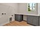 Well-lit laundry room with wood floors, bright white counter, and storage cabinets at 2814 Vogler Ln, North Port, FL 34286