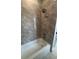 Shower and tub area featuring neutral toned marbled tile at 2814 Vogler Ln, North Port, FL 34286