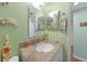 Full bathroom with a granite vanity top, dual mirrors and decorative wall art at 3310 Loveland Blvd # 802, Punta Gorda, FL 33980