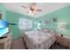 Cozy bedroom boasts a floral bedspread, wall-mounted TV, and soft, natural light at 3310 Loveland Blvd # 802, Punta Gorda, FL 33980
