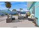 Outdoor patio with modern wicker furniture, cushions, and a view of the yard and fence at 539 Shore Rd, Nokomis, FL 34275