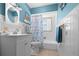 Bright bathroom featuring a tub, seashell themed decor, and a white vanity sink at 539 Shore Rd, Nokomis, FL 34275