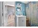 The bathroom features a white single sink vanity, blue walls, round mirror and coastal themed shower curtain at 539 Shore Rd, Nokomis, FL 34275