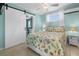 Cozy bedroom with a colorful bedspread and a sliding barn door to the bathroom at 539 Shore Rd, Nokomis, FL 34275