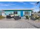 Charming home exterior featuring a blue door, nicely decorated patio, and comfortable outdoor seating at 539 Shore Rd, Nokomis, FL 34275