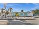 Charming waterfront home with vibrant blue exterior, tropical landscaping, and white picket fence under a clear blue sky at 539 Shore Rd, Nokomis, FL 34275