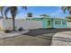 Beautiful blue single-story home with fenced-in yard, paved driveway, tropical landscaping, and a peek of the bright blue sky at 539 Shore Rd, Nokomis, FL 34275