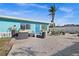 Charming home exterior featuring a blue door, nicely decorated patio, and comfortable outdoor seating at 539 Shore Rd, Nokomis, FL 34275