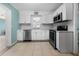 Well-lit kitchen featuring white cabinets, stainless steel appliances, and tile backsplash at 539 Shore Rd, Nokomis, FL 34275
