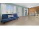 Bright and airy living room with a blue sofa and access to the laundry area at 539 Shore Rd, Nokomis, FL 34275