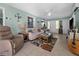 Bright living room with tile floors, ceiling fan, comfortable seating, and colorful floral rug at 539 Shore Rd, Nokomis, FL 34275