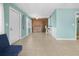 Spacious living room featuring a blue sofa and tile flooring, with access to the laundry area at 539 Shore Rd, Nokomis, FL 34275