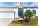 Charming home featuring a lush lawn, beautiful landscaping, and a delightful blue front door at 8768 Conch Ave, Placida, FL 33946