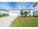 Charming single-story home featuring a lush lawn, a paved driveway and a delightful blue front door at 8768 Conch Ave, Placida, FL 33946