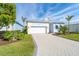 Beautiful single-story home featuring a paved driveway, well-manicured lawn and tropical landscaping at 8768 Conch Ave, Placida, FL 33946