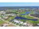 Overhead view of homes in a tranquil neighborhood near a scenic golf course and lake at 109 Westwind Dr, Placida, FL 33946