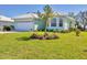 Inviting single-story home with a lush green lawn and mature landscaping at 109 Westwind Dr, Placida, FL 33946