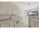 Open kitchen with tiled floors and bright white cabinets at 109 Westwind Dr, Placida, FL 33946