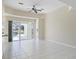 Bright living room with tile floors, ceiling fan, and sliding glass doors to the patio at 109 Westwind Dr, Placida, FL 33946