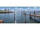 Tranquil water view featuring community dock with wooden pilings under a bright blue sky at 11000 Placida Rd # 301, Placida, FL 33946