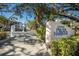 Welcoming entrance to 11000 Placida Harbour with lush landscaping and brick-paved road at 11000 Placida Rd # 301, Placida, FL 33946